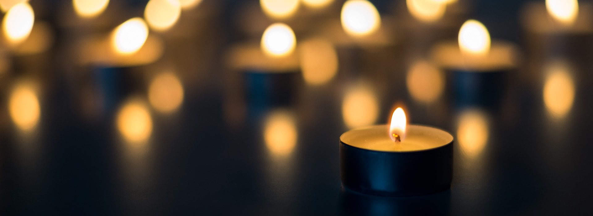 Flamme von vielen Kerzen brennt auf dem Hintergrund blaue Farbe