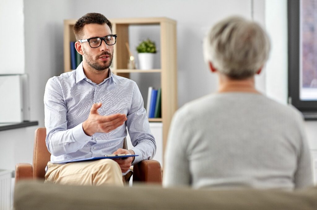 Psychologe im Gespräch mit einer älteren Patientin